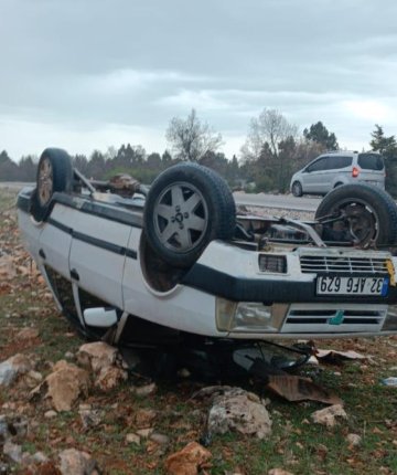 Araziye devrilen otomobilden yara almadan çıktılar