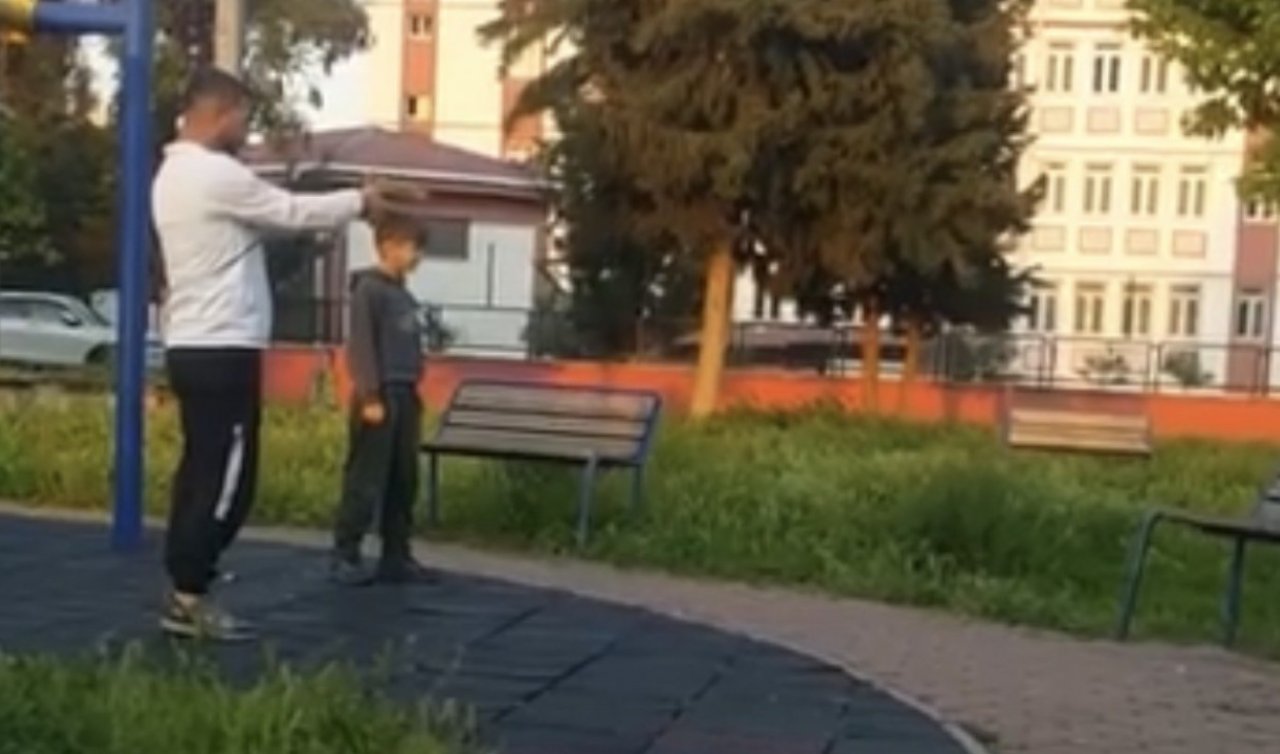 Parkta çocuğa oyuncak silahla atış talimi yaptırdı